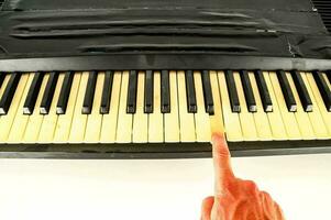 a person is playing a key on the keyboard photo