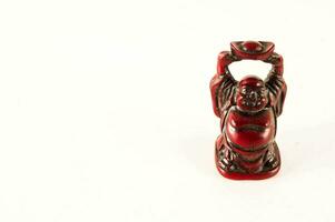 a red figurine of a buddha on a white background photo