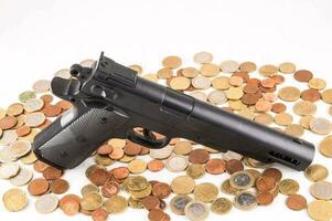 a gun and coins on a white background photo