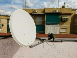 un satélite plato en un techo de un edificio foto