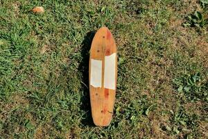 a wooden skateboard laying on the grass photo
