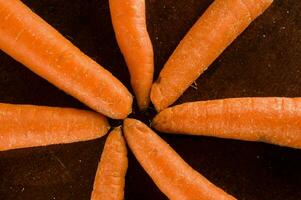carrots arranged in a circle on a wooden surface photo
