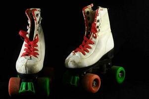 two white roller skates with red laces photo