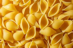 Uncooked Conchiglie Pasta. A Culinary Canvas of Conchiglie Macaroni, Creating a Lively and Textured Background for Gourmet Cooking. Dry Pasta. Raw Macaroni - Top View, Flat Lay photo