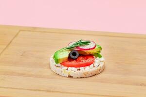 Rice Cake Sandwich with Avocado, Tomato, Cottage Cheese, Olives and Radish on Bamboo Cutting Board. Easy Breakfast. Diet Food. Quick and Healthy Sandwiches. Crispbread with Tasty Filling photo