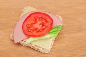 Rice Cake Sandwich with Tomato, Sausage, Green Onions and Cheese on Wooden Cutting Board. Easy Breakfast. Diet Food. Quick and Healthy Sandwiches. Crispbread with Tasty Filling. Healthy Dietary Snack photo