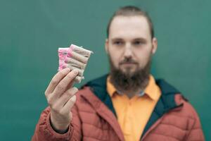 Serious Young Man Holding Firecrackers in his Hand. Bearded Guy Getting Ready for New Year Fun photo