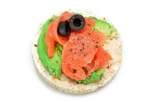 Rice Cake Sandwich with Fresh Salmon, Avocado and Olives Isolated on White. Easy Breakfast. Diet Food. Quick and Healthy Sandwiches. Crispbread with Tasty Filling. Healthy Dietary Snack Isolation photo