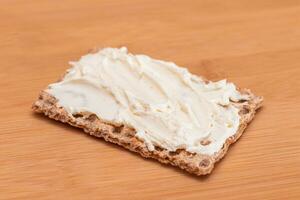 Whole Grain Crispbread with Cream Cheese on Bamboo Cutting Board. Quick and Healthy Sandwiches. Healthy Dietary Snack photo