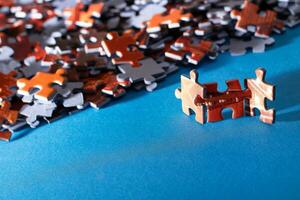 Mixed Peaces of a Colorful Jigsaw Puzzle Lie on the Blue Background Strategy and Solving Problem Concept photo