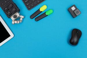 Top View of Photographer's, Videographer's or Video Blogger's Workplace. Digital Gadgets Lying on Blue Table Flat Lay photo