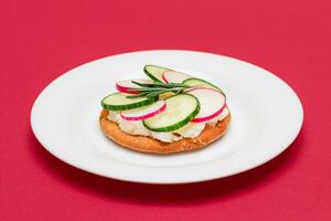 Crispy Cracker Sandwich with Cream Cheese, Fresh Cucumber and Radish on White Plate photo