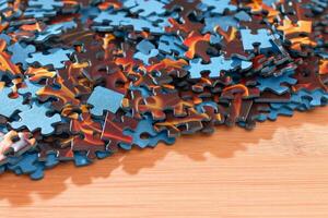 Colorful Peaces of a Mixed Jigsaw Puzzle Lie on the Wooden Table Strategy and Solving Problem Concept photo