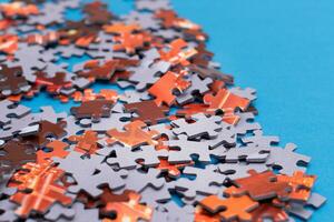 Mixed Peaces of a Colorful Jigsaw Puzzle Lie on the Blue Background Strategy and Solving Problem Concept photo