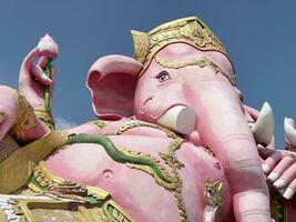 pink ganesh statue on blue sky, thailand photo