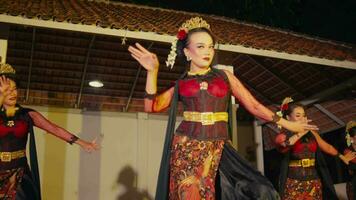 an Asian woman dances on stage while looking at an audience with a piercing gaze to capture the attention video