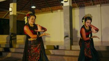 een groep van dansers uitvoeren flexibel bewegingen terwijl het uitvoeren van traditioneel Indonesisch dansen in een paviljoen video