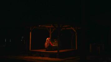 asiatique gens sont performant rituels avec une chaman dans un sinistre cabane avec rouge lumière video