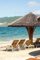 Beach umbrellas and chairs against blue ocean. photo