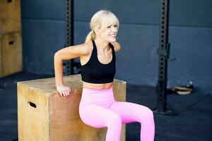 Happy young woman doing exercise in fitness gym photo