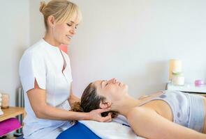 Physiotherapist massaging neck of client in clinic photo
