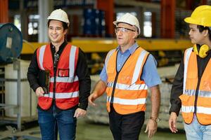 equipo de diversidad trabajador inspeccionando dentro el acero fabricación fábrica mientras escuchando a mayor gerente Consejo en mejora de capacidad y productividad foto