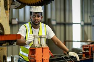 africano americano industrial trabajador es utilizando hidráulico poder prensa máquina a hacer metal y acero parte mientras trabajando dentro el metal sábana galvanizado techo fábrica para la seguridad industria foto