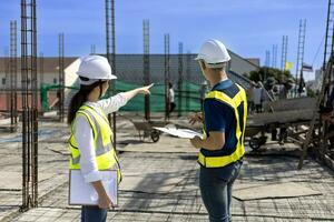 Team of engineering architect inspector and contractor having discussion while examining the quality of construction work of real estate development project photo