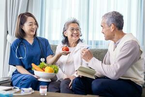 Senior couple got medical advice visit from caregiver nutritionist at home while having suggestion on fresh vegetable meal for healthy eating on probiotic and better digesting system photo