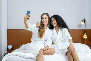 Couple of girlfriend in bathrobe taking selfie after sauna on their spa holiday date for beauty skin therapy and treatment concept photo