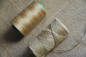 Skeins of thread on burlap. Yellow threads on coarse cloth. photo