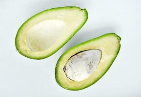 Avocado fruit cut in half on a white background. Green fruits are for vegetarians. Delicious diet food. photo