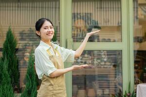 retrato de asiático mujer trabajando en un planta tienda foto