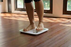 Fat diet and scale feet standing on electronic scales for weight control. Measurement instrument in kilogram for a diet control photo