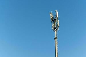 telecomunicaciones torre en pie alto en contra claro azul cielo foto