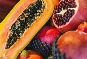 maduro granadas y papaya desplegado en Tienda estante para sano comiendo foto