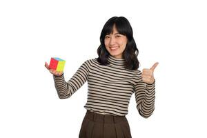 Asian woman holding a puzzle cube standing on white background. solving cubic problems, problem solution and making strategic moves concept photo