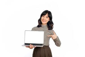 Beautiful young Asian woman on sweater cloth pointing index finger on laptop pc computer and looking at camera with smile face and happy isolated on white background photo
