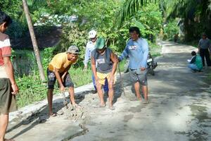 kuaro Kalimantan timur, Indonesia 11 noviembre 2023. el pueblo comunidad estaba visto trabajando juntos a reparar el dañado la carretera foto