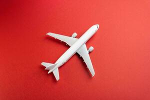 White plane on a red background. Airline operators, air carriers. Business and tourism. Travel. Logistics and transport infrastructure. World communication and commercial flights. photo