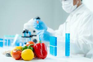 el científico comprueba los residuos de alimentos químicos en el laboratorio. expertos en control inspeccionan la calidad de frutas, verduras. laboratorio, peligros, rohs, encontrar sustancias prohibidas, contaminar, microscopio, microbiólogo foto