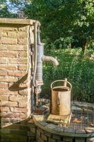 Water pump with rusted watering can photo