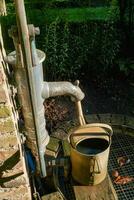 Water pump with rusted watering can photo