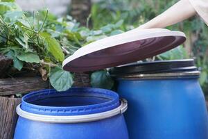 Closeup hand hold lid to cover water bucket to protect from mosquito to breed inside or other insects or dust go into water. Concept, campaign to stop mosquitoes cycle to lay eggs in water container photo