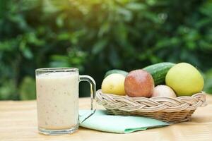 Glass of smoothie mixed fruits and basket of fresh fruits . Concept, healthy beverage for health. Well being and weight loss menu. Homemade refreshing fruit drinks. High fibers, detox. photo