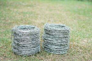 Two rolls of barbed wire. Outdoor background. Concept, construction tool. Barbed wire is used for make fences , secure property ,make border to show the territory of area. photo