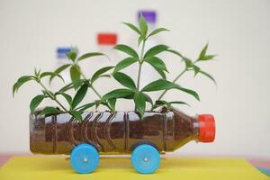 bricolaje coche cuales crecer plantas, hecho desde el plastico botella y tapas. concepto, planta de semillero desde reciclar artesanía. reducir, reutilizar y reciclar el plastico basura foto