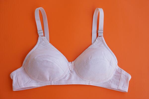 White bra on orange background.Concept, feminine brassiere