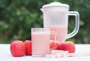 rosado manzana frutas zalamero en vaso y licuadora, al aire libre concepto de fondo, sano bebida para salud. bien siendo y peso pérdida menú. hecho en casa refrescante Fruta bebidas alto fibras, desintoxicación foto