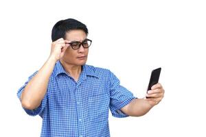 Handsome Asian Middle aged man wears and hold eyeglasses, check his eyesight during read on smartphone, isolated on white background. Concept , Eyesight health problem. Man has farsighted. Optician. photo